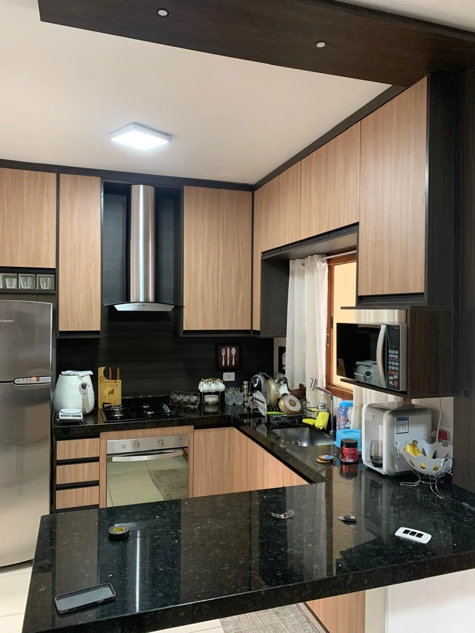 Cozinha planejada com ilha, bancada e armários claros